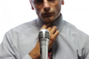 Distressed looking man at a microphone